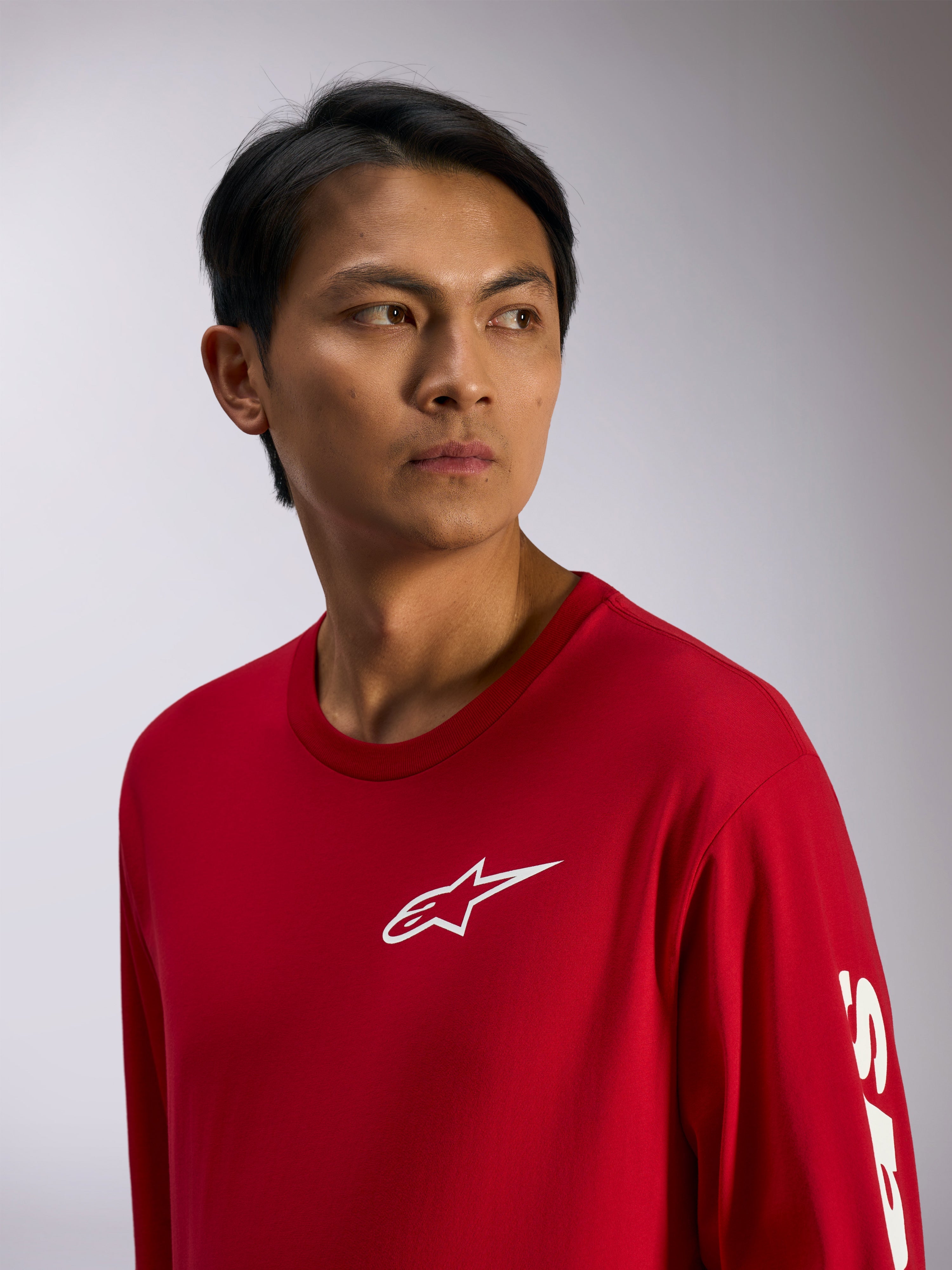 Alpinestars Trackside CSF Tee, T-shirt met lange mouwen, rood met wit Alpinestars-logo op de borst en belettering op de mouw, casual motorsport streetwear, lifestyle portret