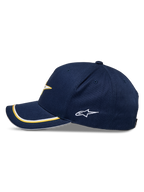 Casquette Snapback Alpinestars Ascension, bleu marine et or, vue de profil avec visière courbée et double passepoil sutache or et blanc, logo latéral brodé, style sportswear décontracté