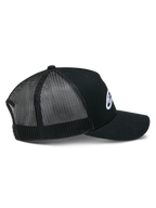 Casquette Trucker Ageless d'Alpinestars, noire, vue de profil montrant la couronne structurée et le logo Astars blanc brodé, visière incurvée et empiècements arrière en maille polyester noire respirante.