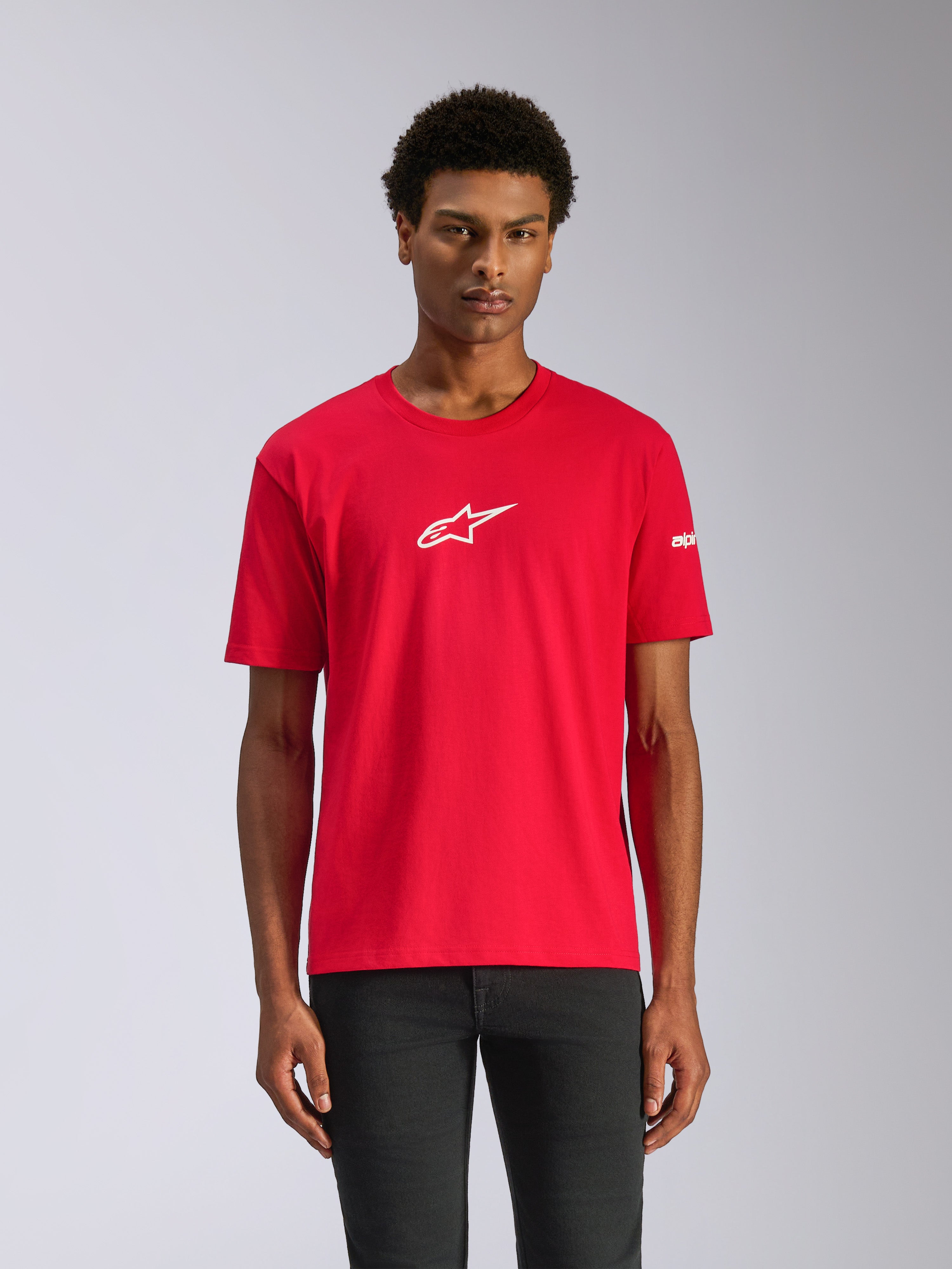 Alpinestars Frontal CSF Tee, T-shirt met korte mouwen, rood, wit ster-logo midden op de borst, gedragen door een model met een donkere broek, casual performance motorsport-geïnspireerd ontwerp