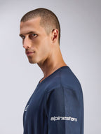 Alpinestars Frontal CSF Tee, T-shirt met korte mouwen, navy blauw, zijprofiel van mannelijk model, wit Alpinestars-logo op de mouw, performance vochtafvoerende stof, casual motorsport lifestyle