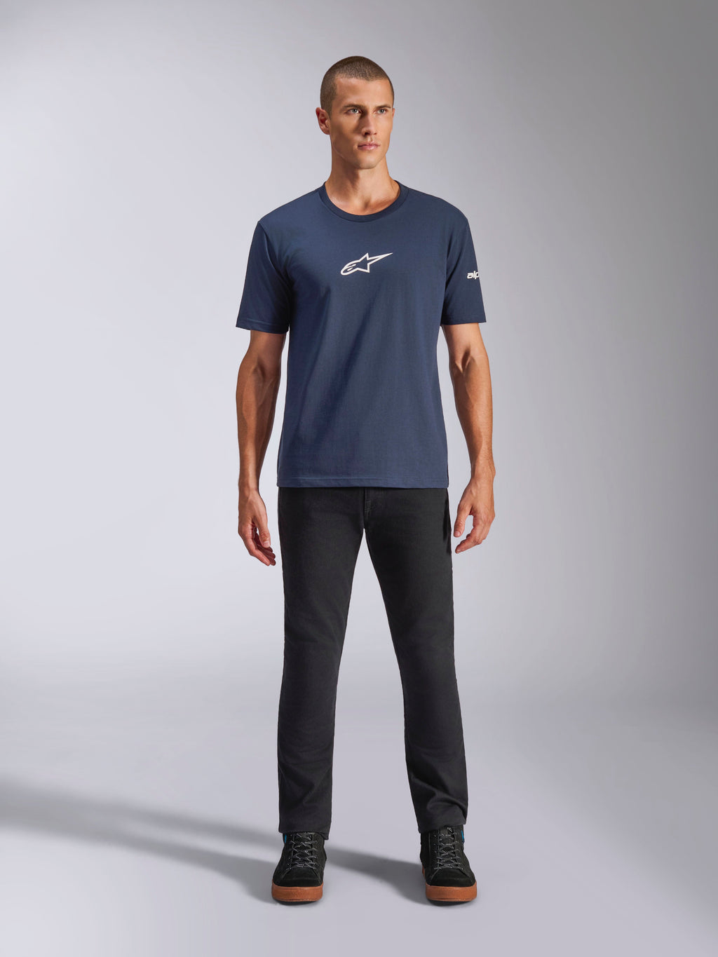 Alpinestars Frontal CSF Tee, T-shirt met korte mouwen, marineblauw, wit Alpinestars sterlogo op de borst, gedragen met een zwarte broek en sneakers, casual performance sportkleding