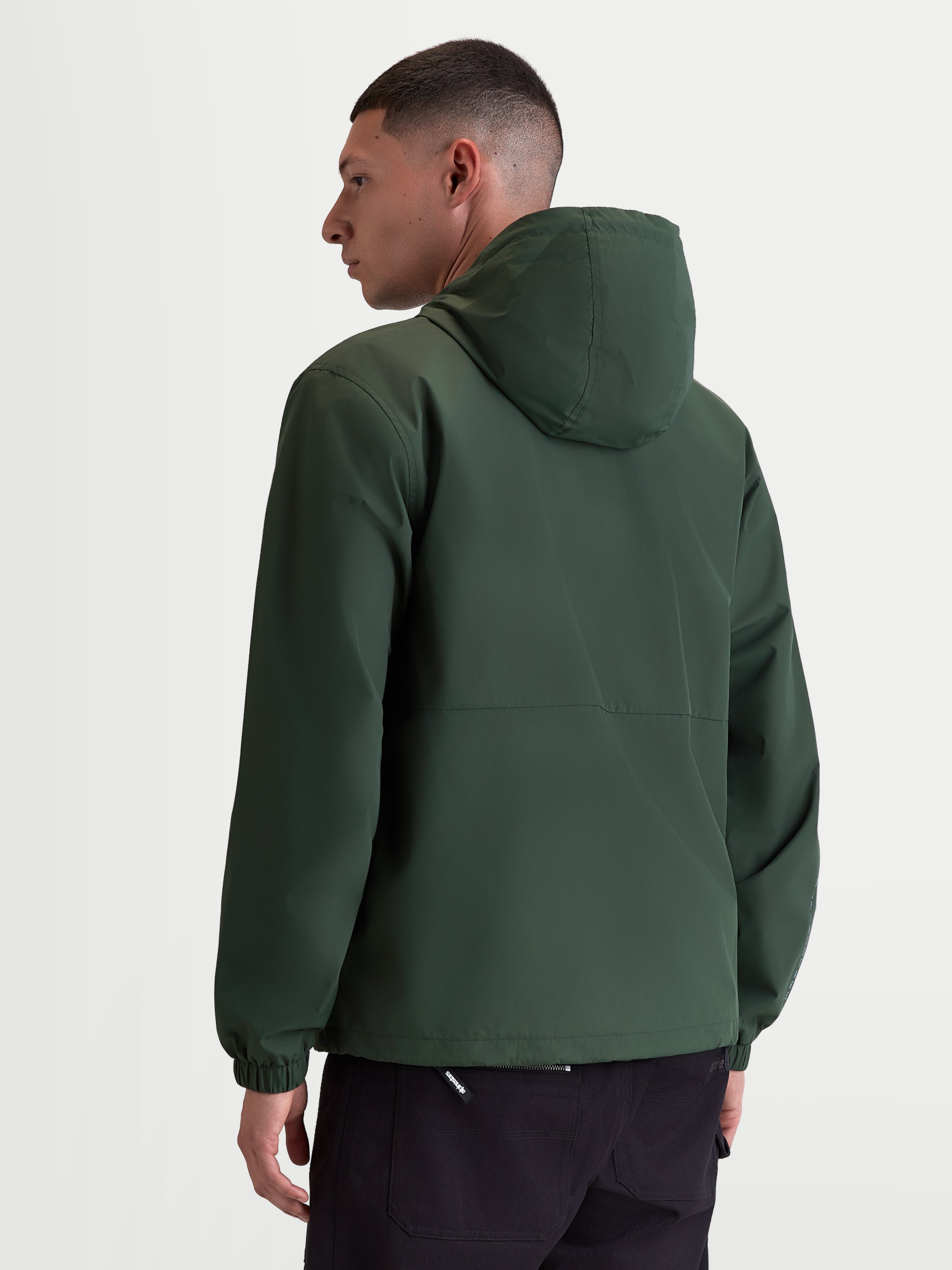 Alpinestars Speeder Resolve, veste coupe-vent sportswear légère pour usage urbain, vert, 100 % polyester avec doublure en mesh, vue de dos sur modèle mettant en valeur le design épuré et les poignets élastiques.