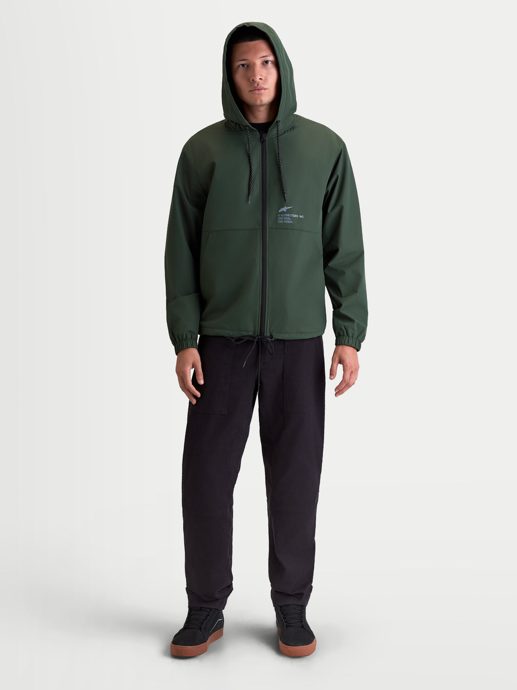 Alpinestars Speeder Resolve, veste coupe-vent de sportswear légère pour homme et femme, vert pin, 100 % polyester, avec capuche réglable, fermeture éclair inversée et marquage Alpinestars, vue de face sur modèle