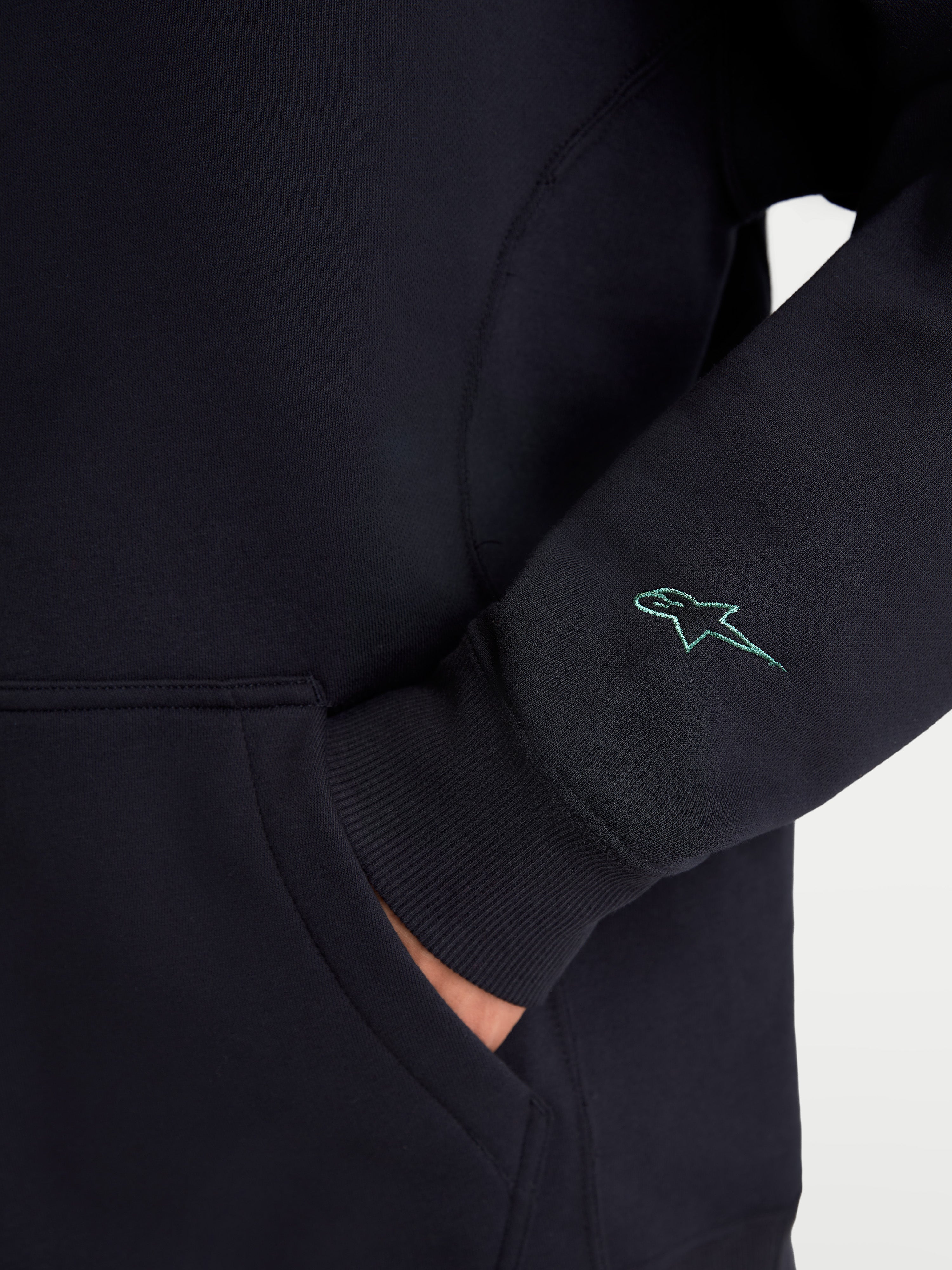 Alpinestars Guise Oversized Crew, pull sportswear en polaire, noir, gros plan du logo Astars brodé sur la manche, poignets côtelés et détail de la poche kangourou, mélange de coton et polyester recyclé, coupe oversize décontractée