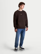 Alpinestars Guise Oversized Crew, Brown Sportswear Pullover for Men, on-model view. This relaxed-fit crewneck sweatshirt features a front kangaroo pocket, ribbed cuffs, and embroidered Astars branding on the chest. Made from a comfortable cotton and recycled polyester blend for a premium lifestyle and motorsport-inspired look.