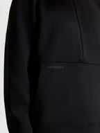Alpinestars Sweat Half-Zip Apera, pull sportswear noir, gros plan montrant le logo HD ton sur ton sur la poche kangourou et le design demi-zippé, polaire tri-mélange premium.