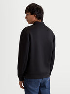 Alpinestars Sweat Half-Zip Apera, pull sportswear inspiré du sport automobile pour homme, noir, confection en polaire double face tri-mélange, vue de dos sur modèle montrant la coupe lifestyle épurée et les coutures de manches raffinées.