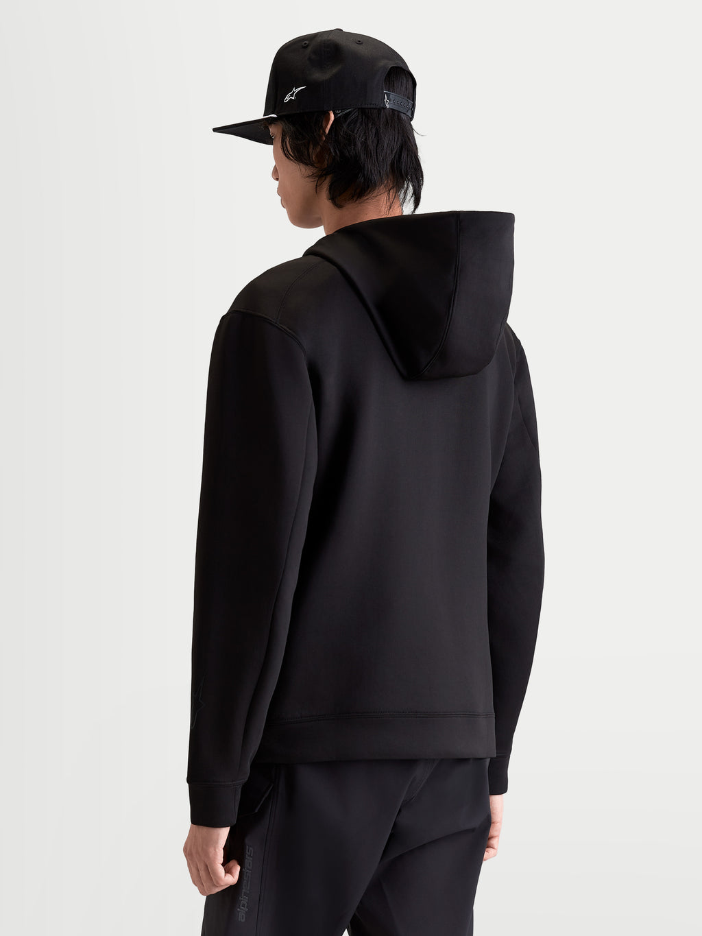 Alpinestars Sweat à capuche Datrix, sweat à capuche sportswear pour homme, noir, construction en polaire double face et capuche doublée en mesh, vue de dos sur modèle, style inspiré du sport automobile