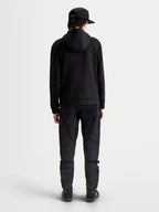 Alpinestars Sweat à capuche Datrix, sweat sportswear premium, noir, vue de dos sur modèle, polaire double face tri-mélange avec capuche doublée en mesh, style épuré inspiré du sport automobile.