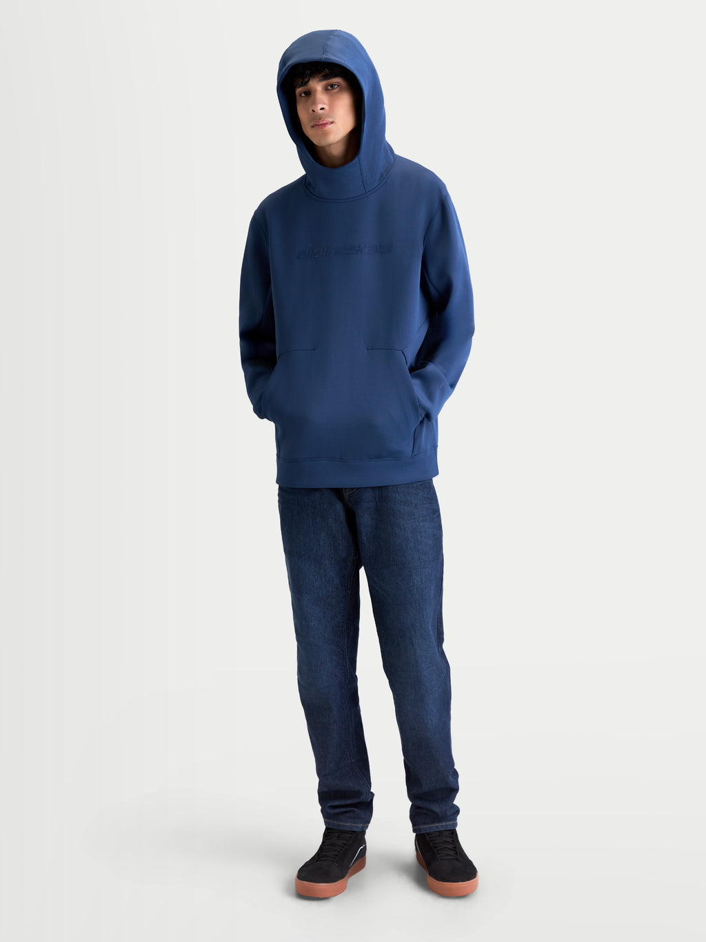 Alpinestars sweat à capuche Datrix, pull sportswear pour homme, bleu, polaire premium tri-mélange avec logo HD ton sur ton sur la poitrine, capuche doublée en mesh relevée sur un modèle.