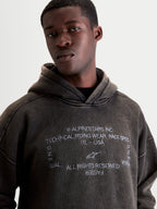 Alpinestars Sweat à capuche Infinite Washed Oversize, sweat à capuche sportswear pour homme, noir délavé avec finition effet neige, logos et texte One Goal One Vision brodés en blanc, coupe oversize décontractée, vêtement en polaire.
