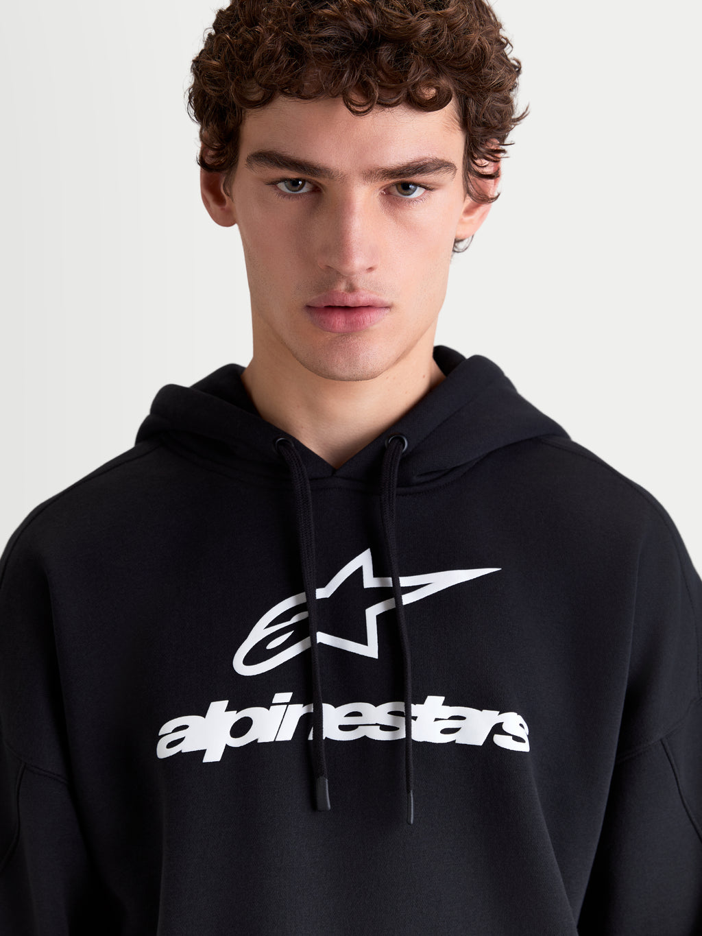 Alpinestars Prelude Oversized Hoodie, sweat à capuche de style sportswear pour homme, noir et blanc, avec un logo en relief sur la poitrine, capuche doublée avec cordons plats et coupe ample pour un confort quotidien