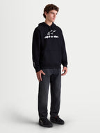Alpinestars sweat à capuche Prelude Oversized, sweat en polaire sportswear pour homme, noir et blanc, coupe décontractée avec logo en impression en relief et poche kangourou, porté par un mannequin.