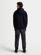 Alpinestars sweat à capuche Prelude Oversized, sweat à capuche noir de style sportswear, vue de dos sur modèle, coupe ample décontractée avec épaules tombantes et ourlet côtelé, vêtement décontracté quotidien