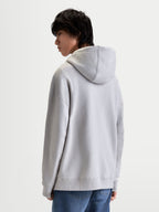Alpinestars Prelude oversized hoodie, grijze sportswear fleecepullover voor heren en dames, ontspannen silhouet met gevoerde capuchon en mouwnaden, achteraanzicht op model.