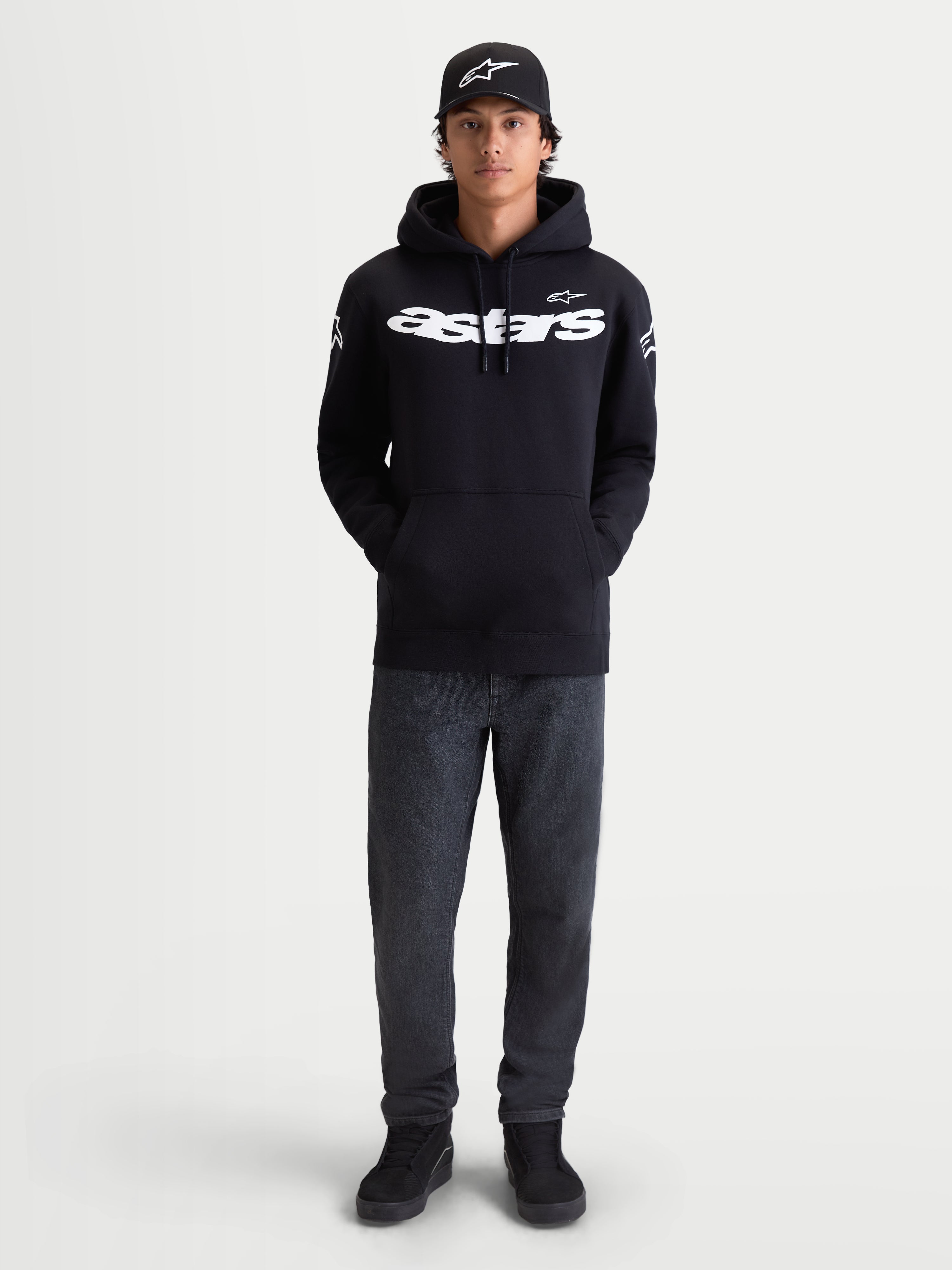 Alpinestars Sweat À Capuche Velocifier, sweat à capuche de sportswear pour homme, noir et blanc, logo Astars blanc sur le devant et les épaules, polaire premium, porté par un modèle avec une casquette pour un look décontracté