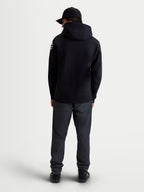 Alpinestars Velocifier, sweat à capuche de sportswear pour homme en polaire, noir, mélange de coton et polyester recyclé, vue de dos sur modèle montrant la capuche et les logos Alpinestars blancs sur les épaules.