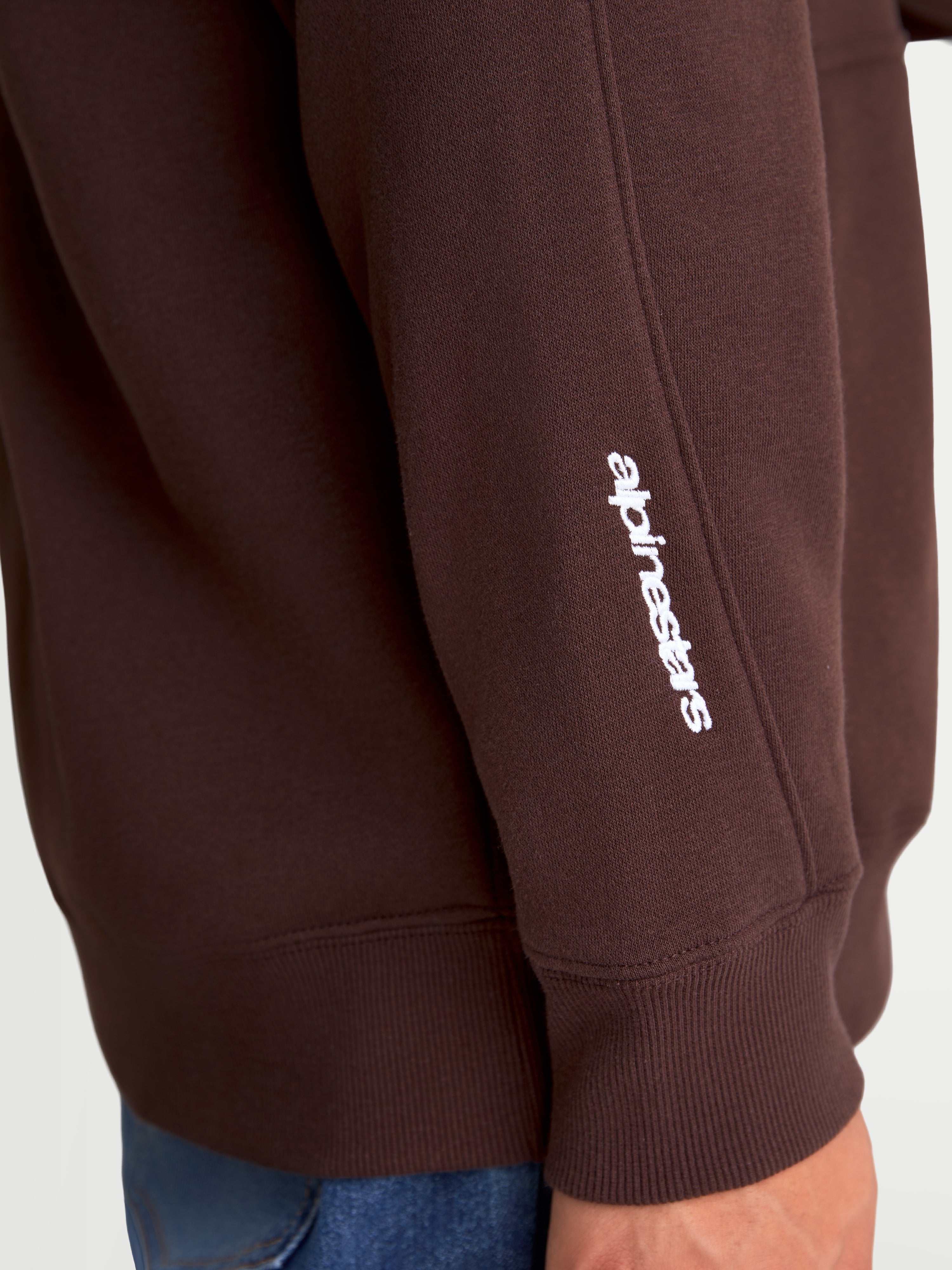 Alpinestars Sweat À Capuche Entity Oversized, sweat à capuche sportswear marron, détail de la manche avec logo Alpinestars brodé en blanc, poignet côtelé premium, polaire en mélange de coton recyclé