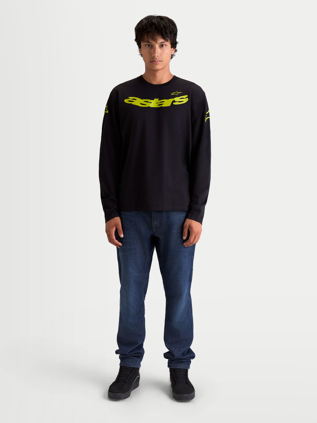 Alpinestars Velocifier CSF t-shirt met lange mouwen, zwart en geel, motorsport-geïnspireerde casual sportswear, gebogen Astars-graphic op de borst, op model gedragen.
