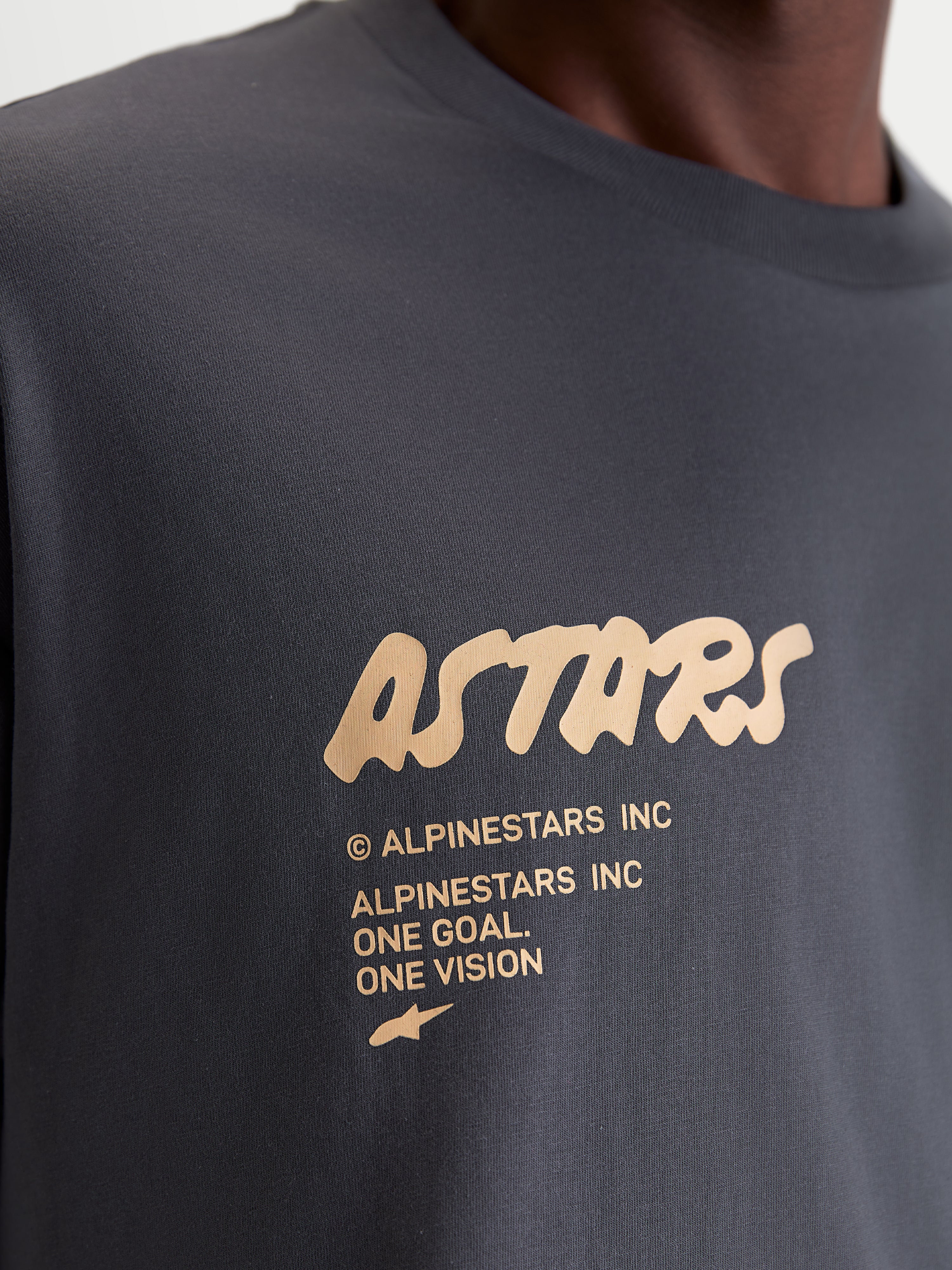 Alpinestars Chalk Oversized CSF, t-shirt de sportswear, gris anthracite et beige, gros plan sur le logo Astars et le slogan One Goal One Vision, coupe oversize décontractée