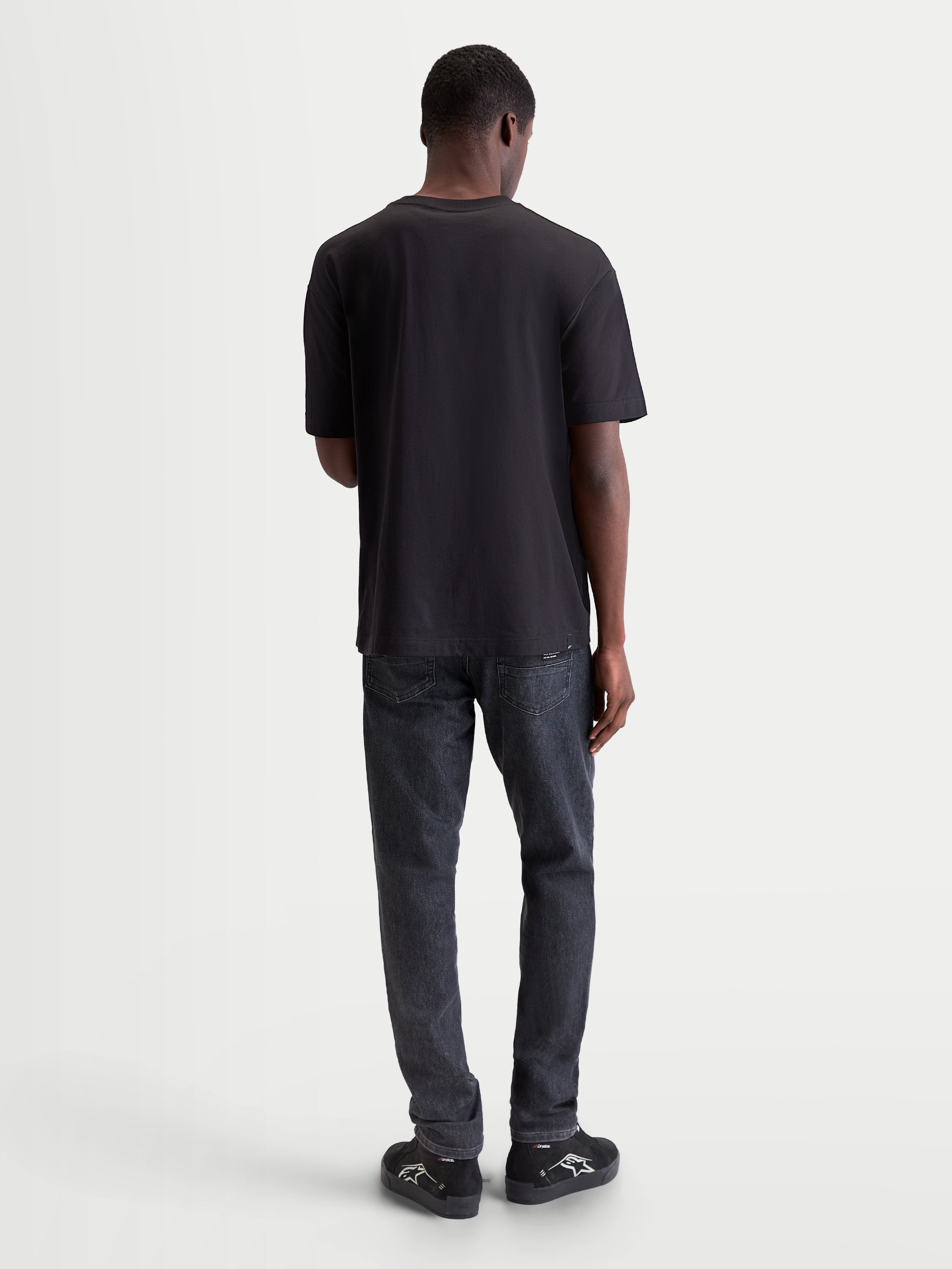 Alpinestars Infinity Oversized CSF Tee, Black Short Sleeve Sportswear T-Shirt, Back View on Model, Relaxed Fit for Everyday Comfort and Off-Bike Style.