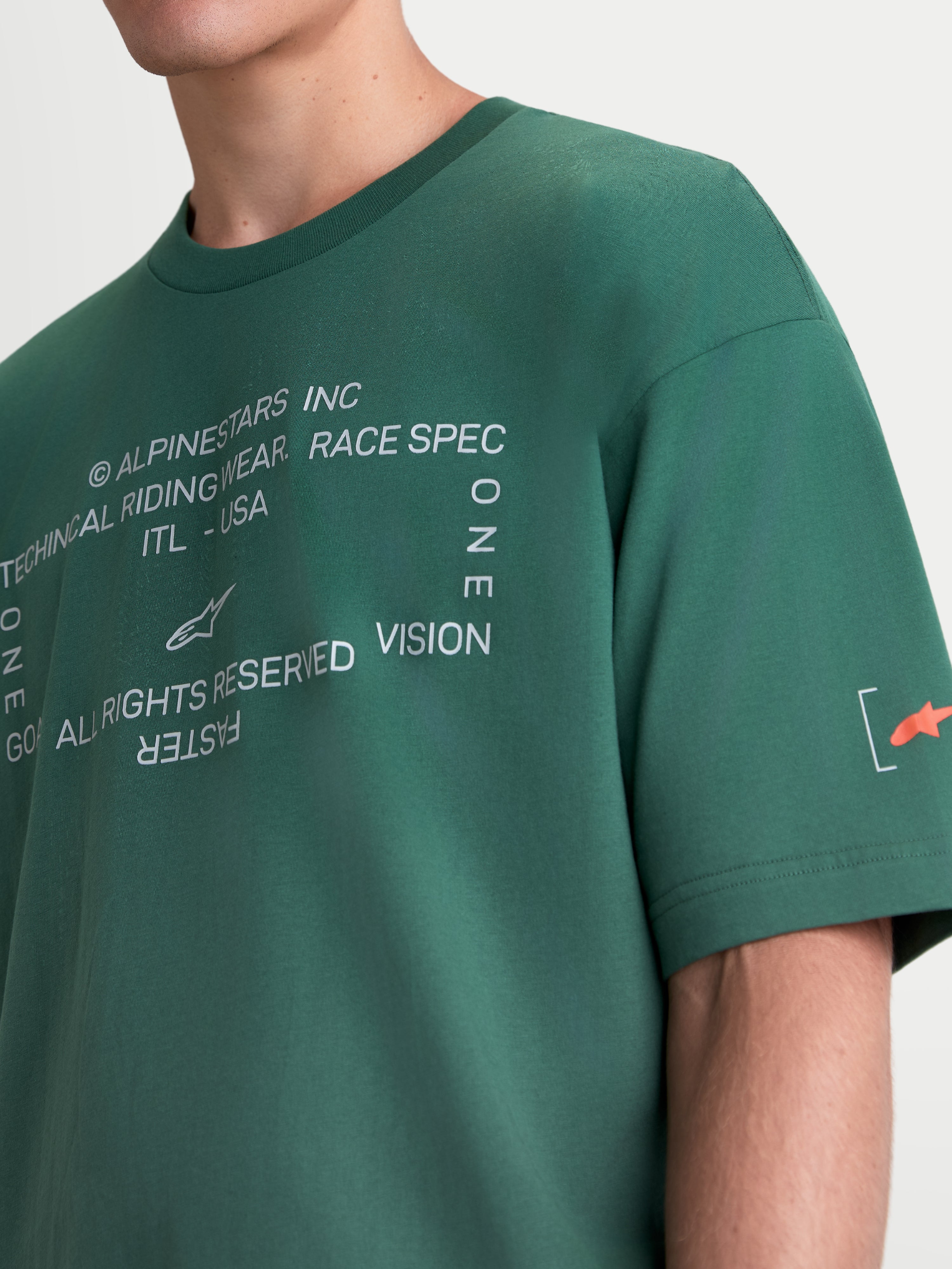 Alpinestars T-Shirt Infinity Oversized CSF, t-shirt sportswear à manches courtes unisexe, vert, vue rapprochée du graphique blanc sur la poitrine et du logo Astars orange sur la manche, mélange de coton et polyester, style décontracté