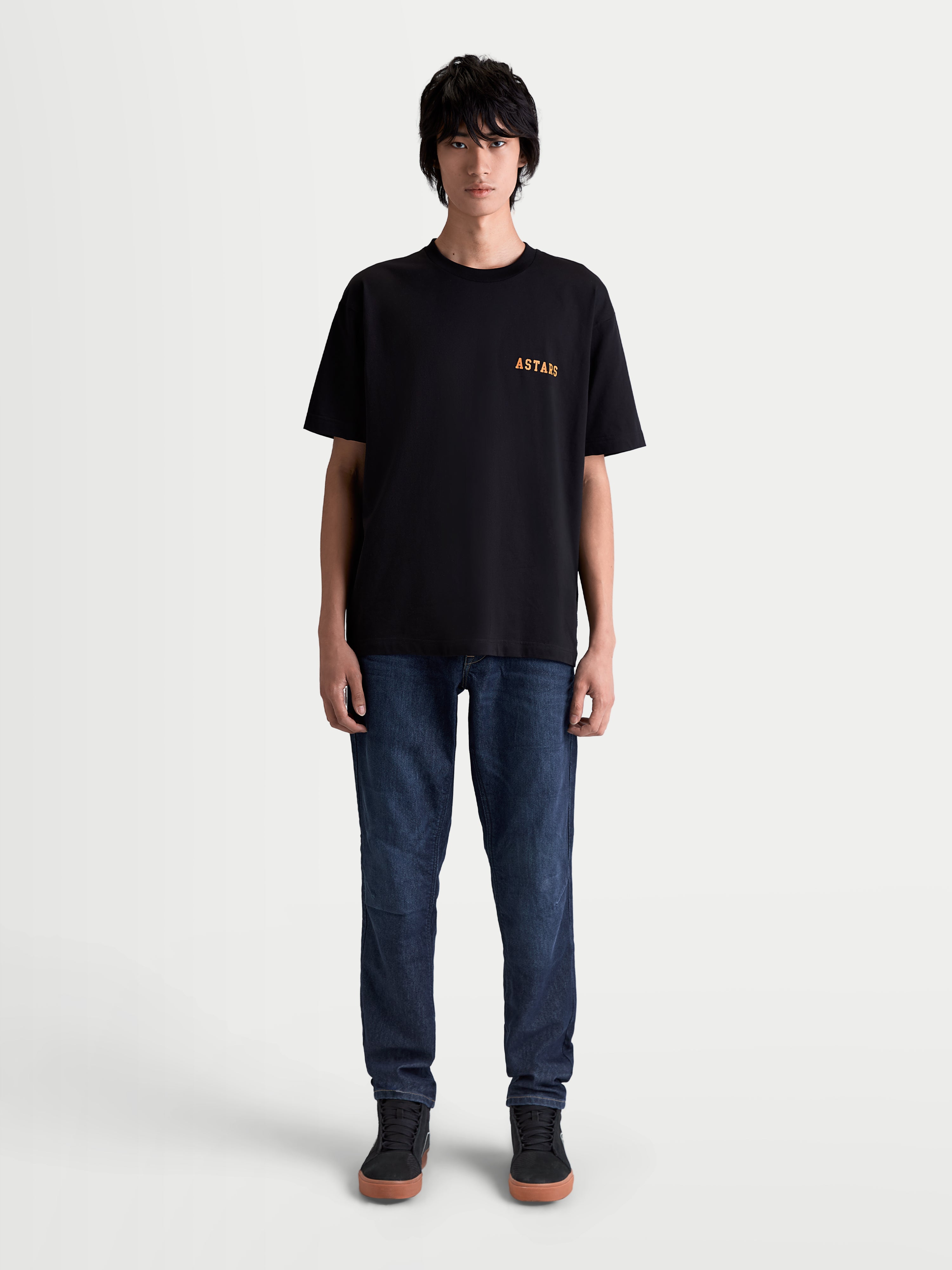 Alpinestars Latitude Oversized CSF t-shirt, sportswear t-shirt met korte mouwen, zwart en oranje, relaxte oversized pasvorm, premium katoen-polyestermix, voorzien van ASTARS-borstlogo op model.