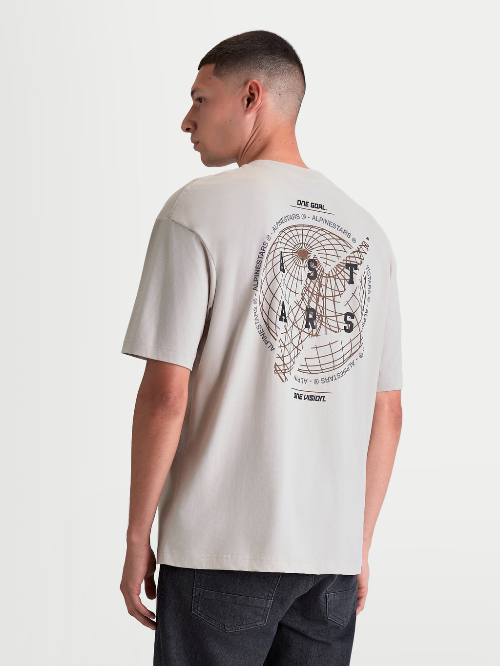 Alpinestars T-shirt Latitude Oversized CSF, t-shirt sportswear à manches courtes pour homme, gris ciment, vue de dos avec un large graphique de globe, le logo ASTARS et le slogan One Goal One Vision, coupe oversize.