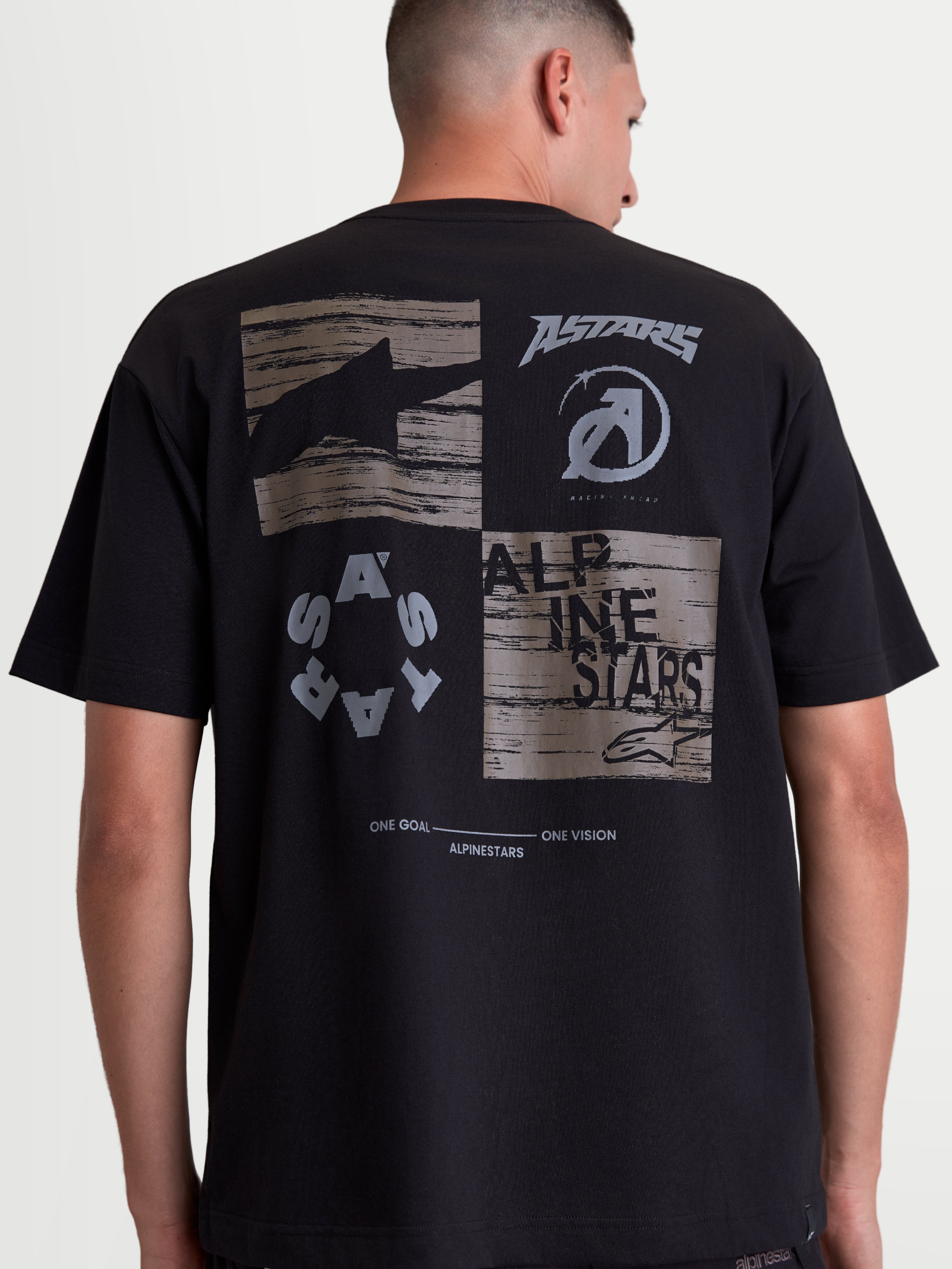 Alpinestars Checkback Oversized CSF t-shirt, zwart sportswear t-shirt met korte mouwen, achteraanzicht op model met een grote grijze graphic, Astars-logo's en 'One Goal One Vision' slogan, oversized fit, katoen-polyester mix.