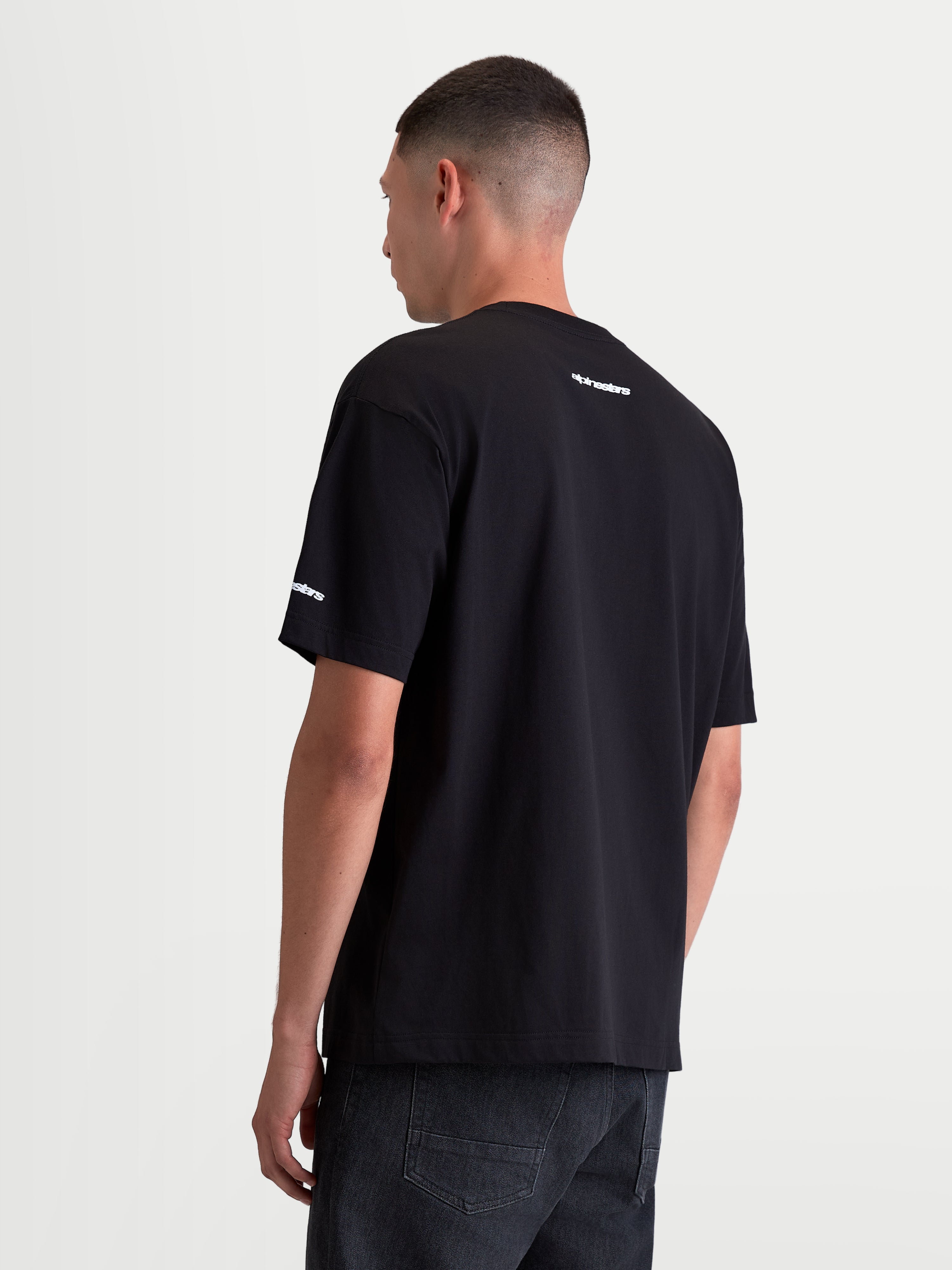 Alpinestars Mandate Oversized CSF, t-shirt de sportswear pour homme à manches courtes, noir avec logos wordmark blancs, vue de dos montrant le marquage sur la nuque et la manche, coupe oversize décontractée