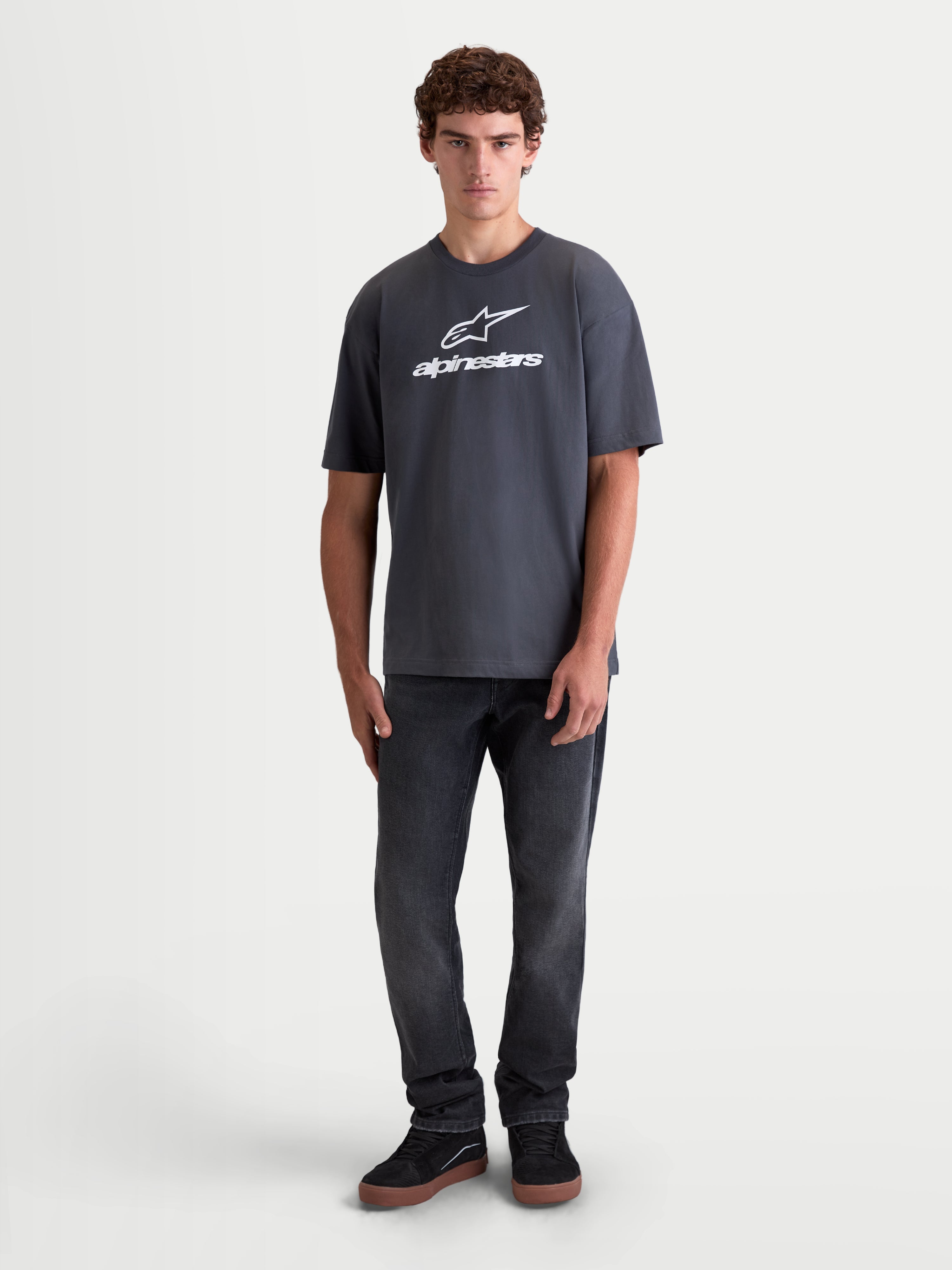 Alpinestars Prelude Oversized CSF t-shirt, heren-t-shirt met korte mouwen, grijs met wit Alpinestars-logo op de borst, oversized pasvorm, katoen-polyestermix, sportswear, vooraanzicht op model.