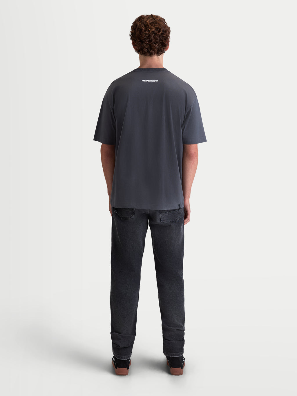 Alpinestars Prelude Oversized CSF T-shirt, heren-sportswear-t-shirt met korte mouwen, grijs, voorzien van een klein wit logo op de bovenrug, relaxte oversized pasvorm, zachte katoen-polyestermix, achteraanzicht op model.