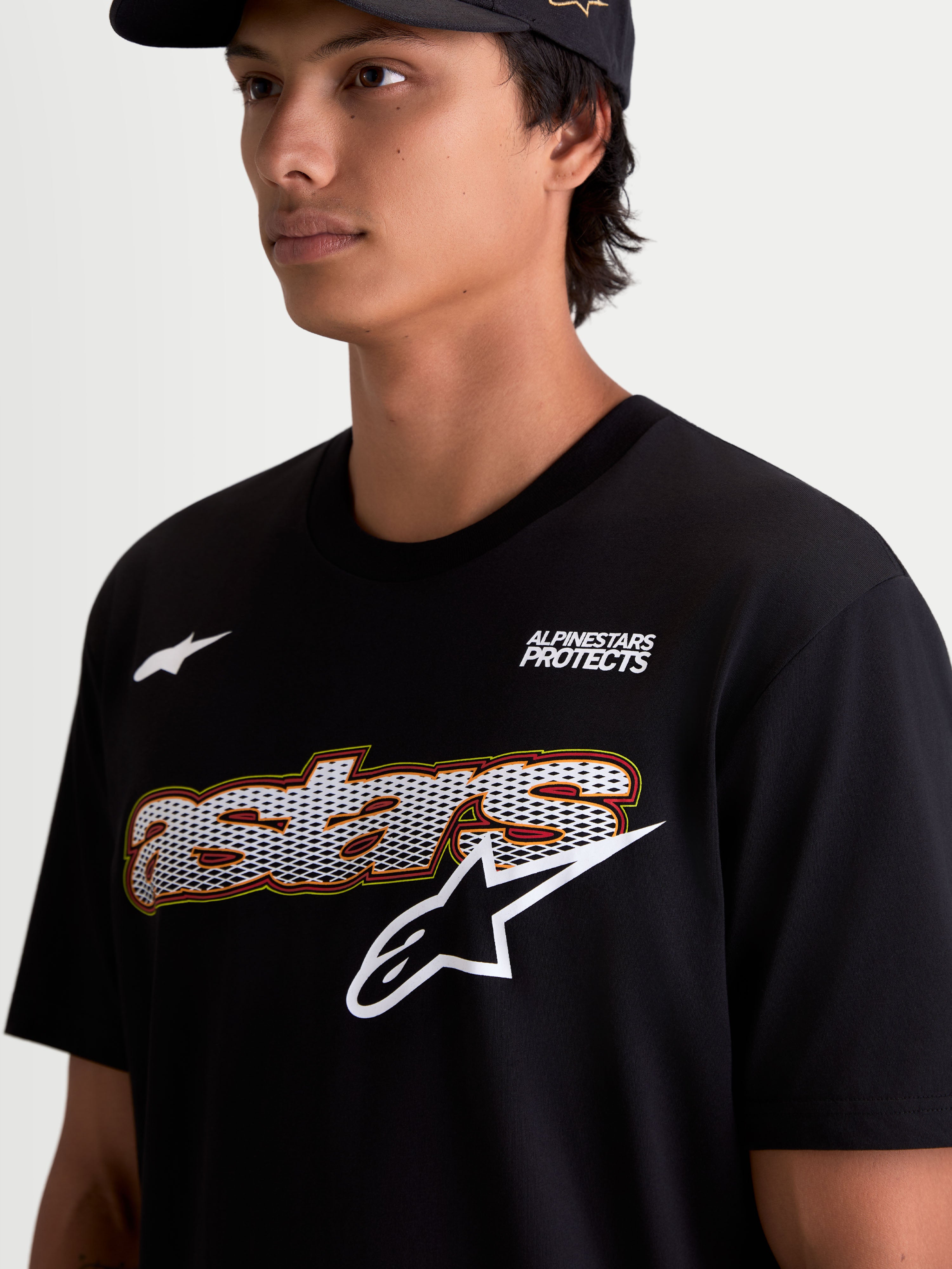 Alpinestars T-Shirt Cypress CSF, t-shirt sportswear à manches courtes pour homme, noir, graphique frontal avec mot-symbole Astars en mesh et logo blanc, marquage Alpinestars Protects, vue rapprochée sur modèle.