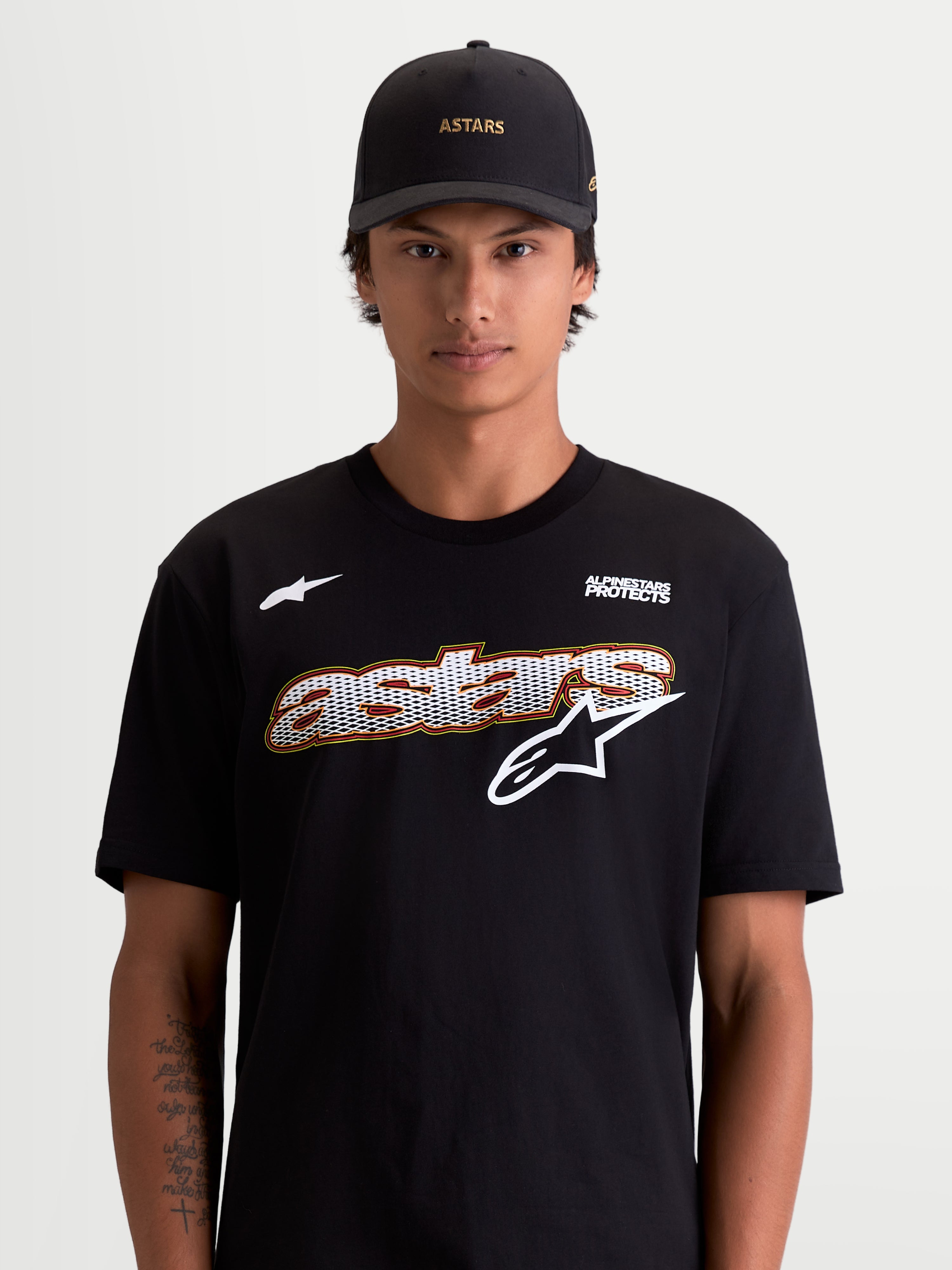 Alpinestars Cypress CSF T-shirt, heren-T-shirt met korte mouwen, zwart en wit, met een astars mesh-fill graphic op de voorzijde en Alpinestars Protects-logo, lifestyle-aanzicht op model, premium katoen-polyester materiaal.