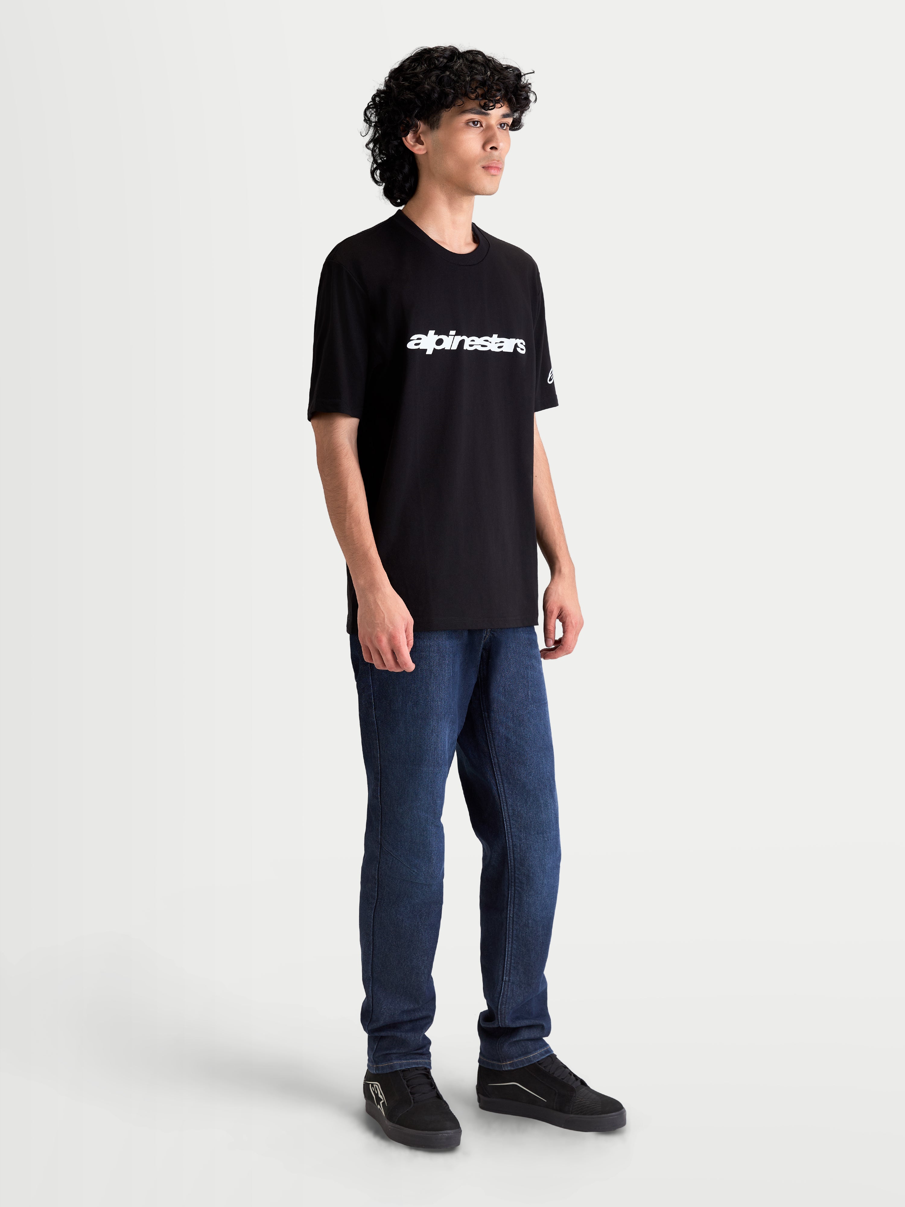 Alpinestars T-shirt Race Wordmark CSF, t-shirt de sportswear à manches courtes pour homme et femme, noir et blanc avec wordmark blanc sur le devant et logo sur la manche, vue sur modèle, style motorsport