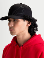 Alpinestars Casquette Maze, casquette de sportswear noire pour homme, avec couronne structurée, visière incurvée et logo Astars Corp Shift texturé, vue de profil sur modèle.