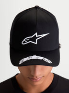 Alpinestars Arclight, casquette de sportswear noire et blanche, portée par un modèle, vue de face montrant le logo Astars blanc en relief texturé sur une couronne structurée et logo incurvé sur la visière, style décontracté inspiré du motorsport