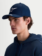 Alpinestars Casquette Arclight, casquette de sportswear bleu marine, visière incurvée et couronne structurée, logo Astars blanc imprimé en relief, vue de profil sur mannequin montrant la coupe motorsport en sergé de coton.