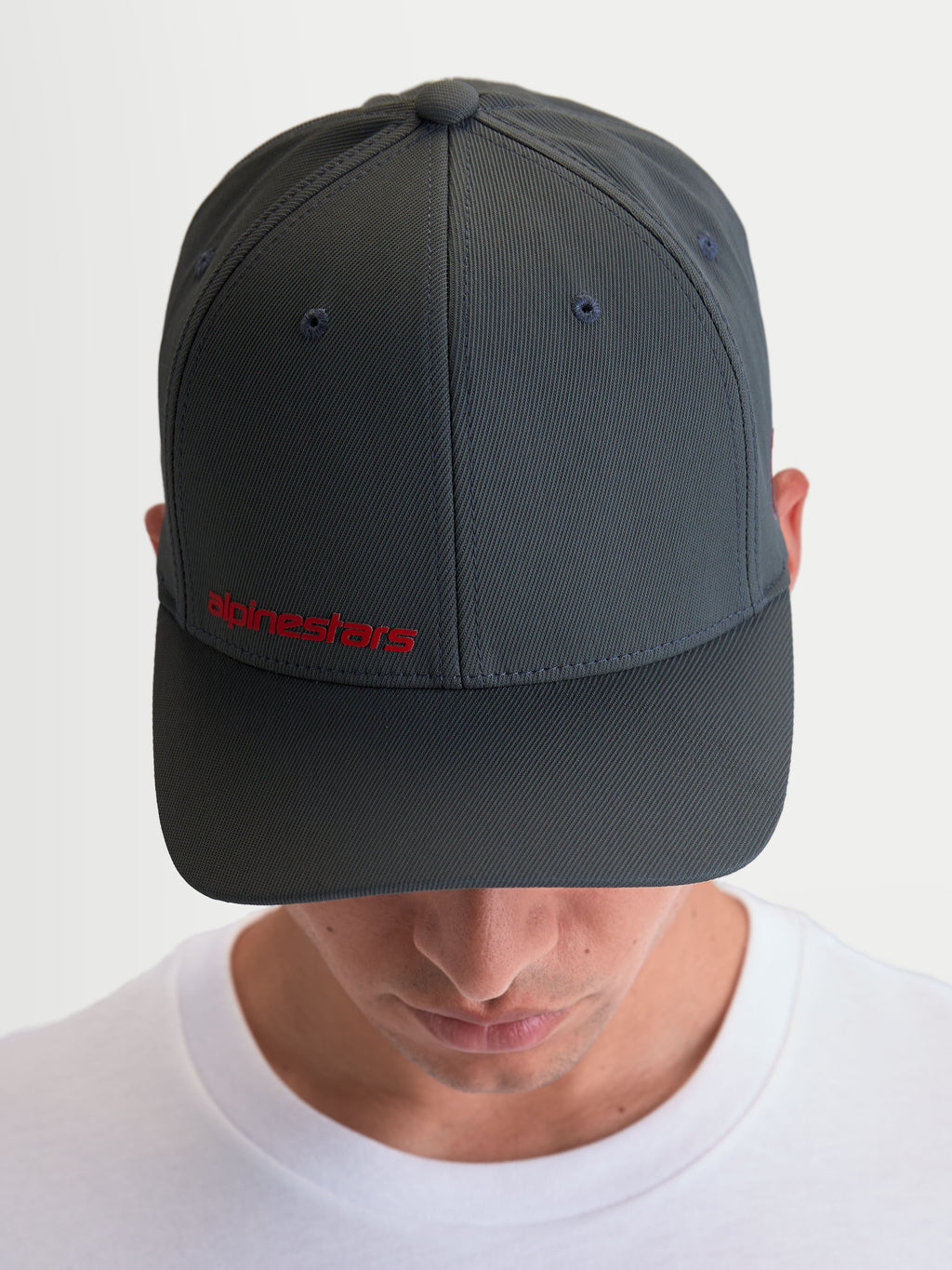 Alpinestars Casquette Points, casquette sportswear pour homme à visière incurvée, gris foncé et rouge, construction en nylon tactel léger, logo Alpinestars rouge sur le devant, style motorsport décontracté.