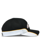 Alpinestars Casquette 500 Snapback, casquette sportswear inspirée du motorsport, noire et blanche avec liseré orange, vue de profil montrant la visière incurvée, la couronne structurée et le passepoil contrasté