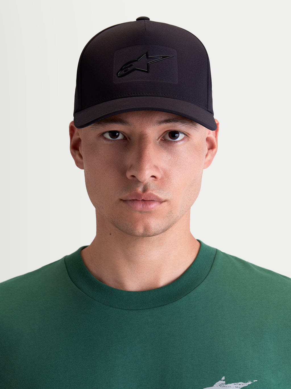 Alpinestars Algo Perf Adjustable, casquette snapback de sportswear pour homme et femme, noire, tissu technique avec logo Astars soudé par ultrasons, couronne structurée et visière incurvée, vue de face sur modèle