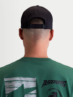 Alpinestars Algo Perf Adjustable, casquette de sportswear noire, vue arrière sur modèle montrant la fermeture ajustable, style inspiré du sport automobile, tissu technique, unisexe