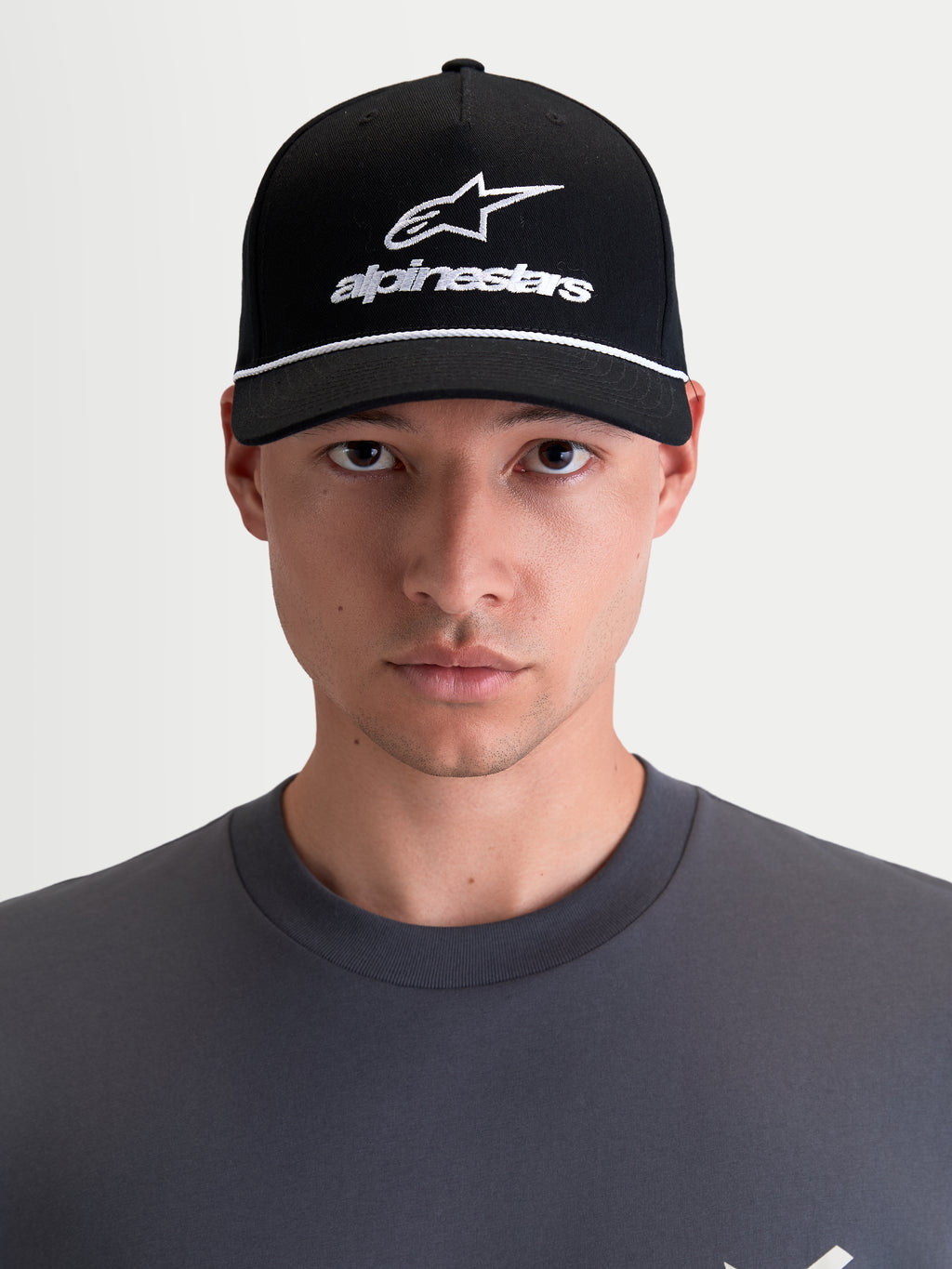 Alpinestars Casquette Combo Logo Snapback, casquette de sportswear moto unisexe, noire et blanche, avec visière courbée, couronne structurée et logo Astars brodé, 100 % sergé de coton, vue de face sur modèle.