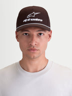 Alpinestars Combo Logo Snapback, casquette de sportswear avec visière courbée, marron et blanche, en sergé de coton durable avec logo brodé, style motorsport décontracté, vue de face sur modèle.