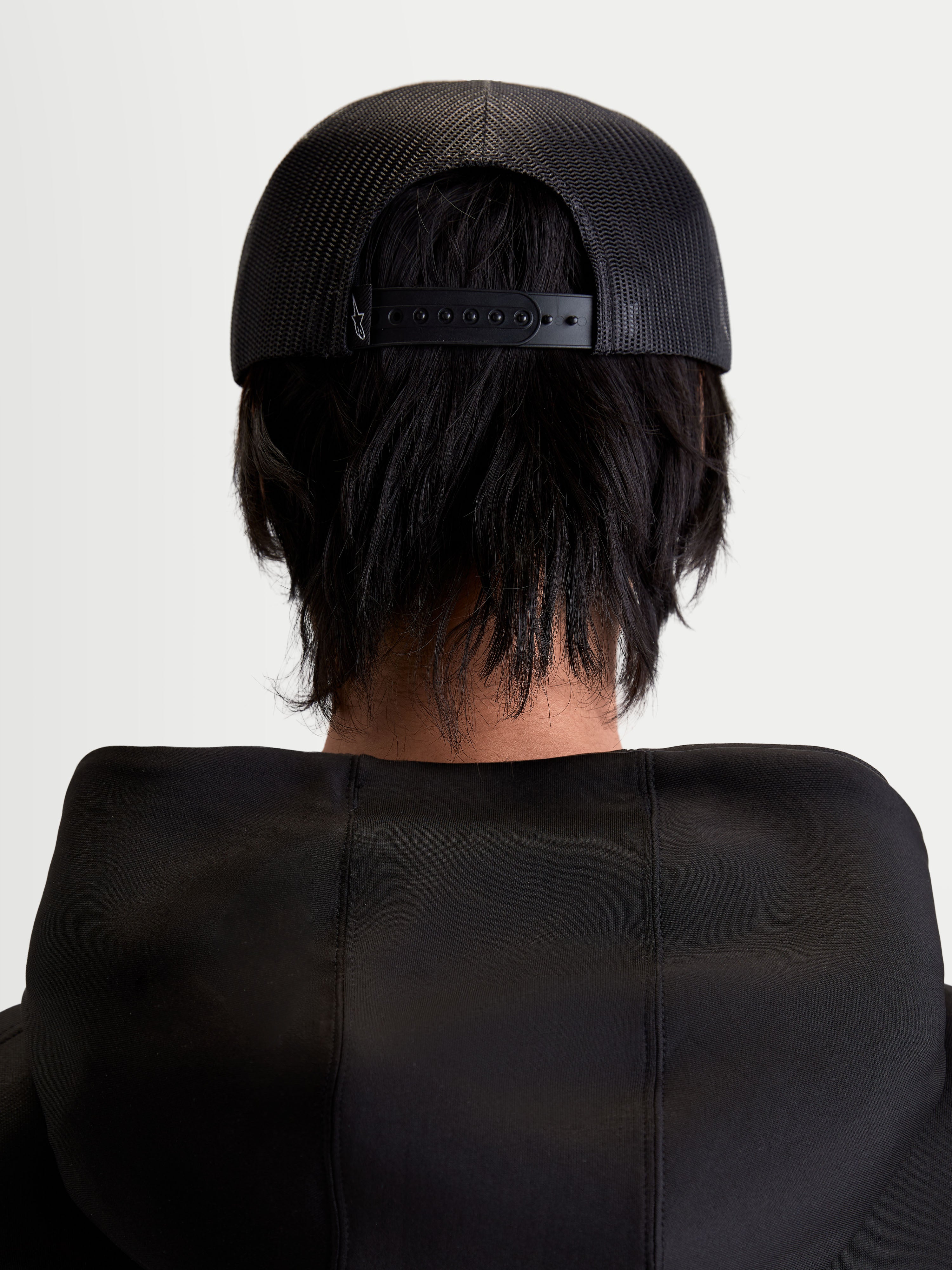 Alpinestars Gravel Trucker Hat, Sportswear Snapback Cap, Unisex, Black, Rear View on Model showing the Breathable Poly Mesh Back and Adjustable Snapback Closure.