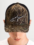 Alpinestars Thicket Realtree Trucker Hat, sportswear trucker cap worn by a model, Realtree camo and black, curved bill, structured crown, and white embroidered Astars logo on the front