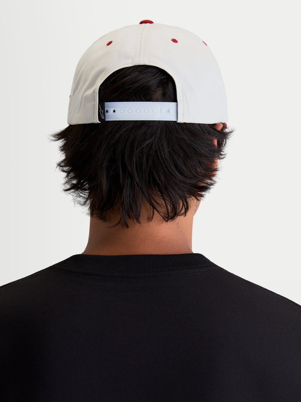 Alpinestars Casquette Stadium Snapback, casquette sportswear décontractée, blanc cassé et rouge, avec fermeture snapback réglable et couronne structurée, vue de dos sur modèle montrant l'ajustement pour un style de vie inspiré du motorsport.