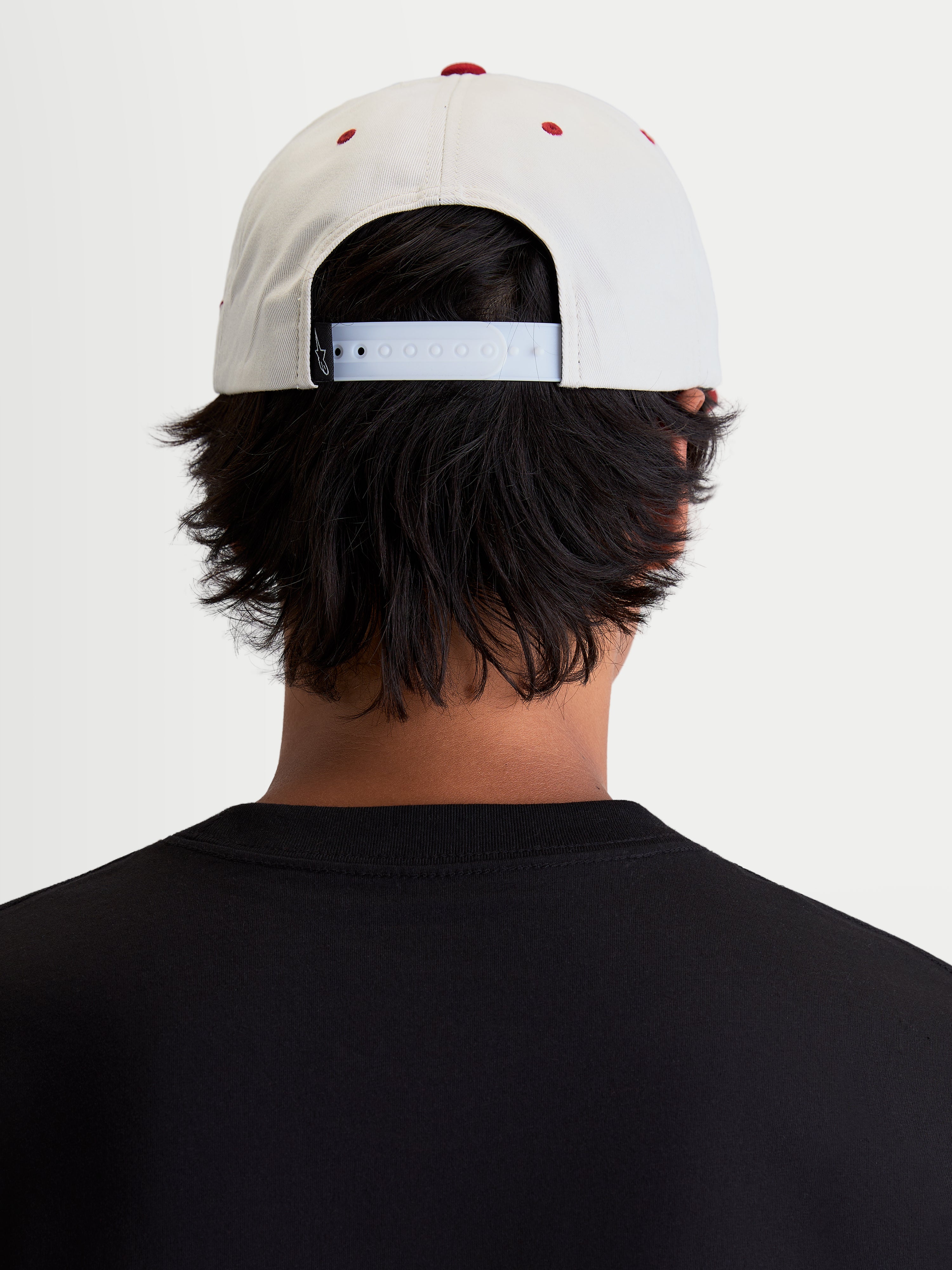 Alpinestars Casquette Stadium Snapback, casquette sportswear décontractée, blanc cassé et rouge, avec fermeture snapback réglable et couronne structurée, vue de dos sur modèle montrant l'ajustement pour un style de vie inspiré du motorsport.
