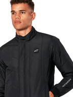 Alpinestars Precedent jas, gestept sportjack voor heren in het zwart, close-up van de lage kraag, logopatch op de borst en het borduursel op de mouw, met een iconisch schuin gestikt patroon voor een op de motorsport geïnspireerde look.